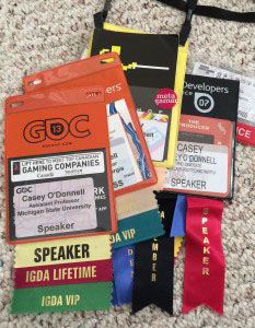 Photograph of a pile of GDC Badges on carpet.