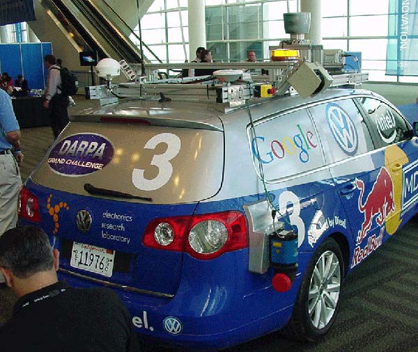 Photograph of Winning Stanford Vehicle for the DARPA challenge. It is a blue and silver hatchback vehicle covered in logos.