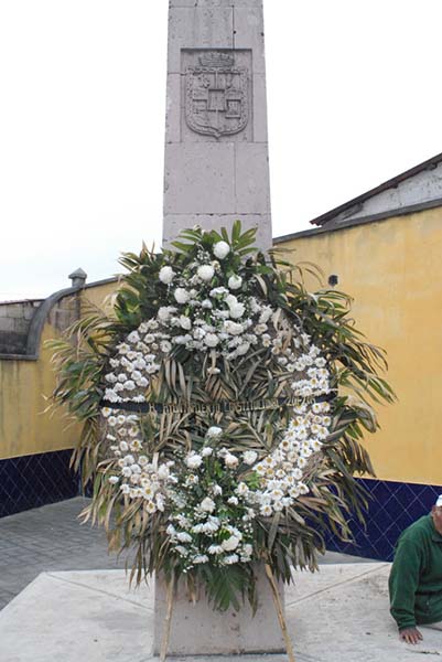 Photograph of memorial with large wreath.