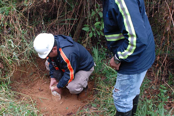 Two men taking samples in the soil.