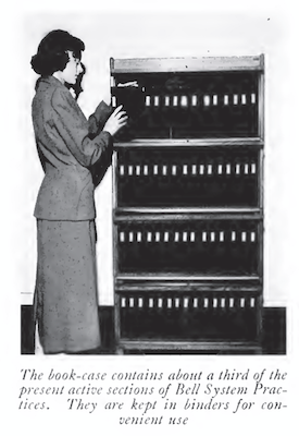 Black and white photograph of a woman at a shelf.