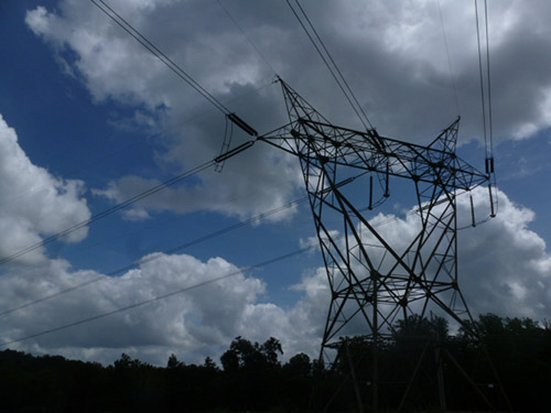 Photograph of electrical wires and tower against the sky