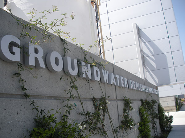Photograph of a concrete wall with metal letters on it that say Groundwater Replenishment System