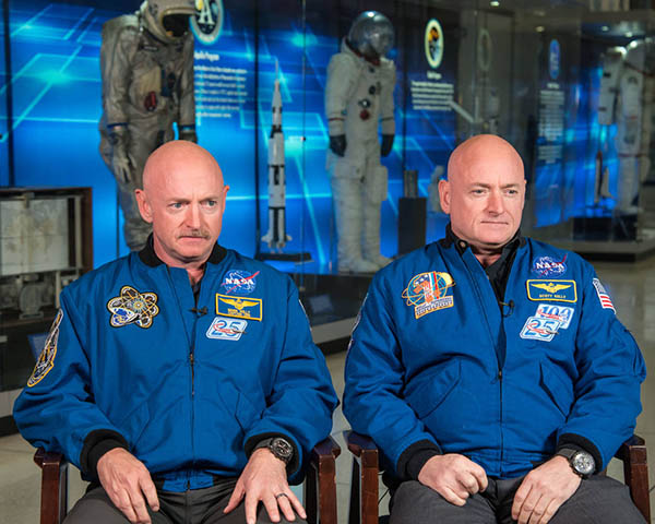 Scott and Mark Kelley seated facing the camera with museum displays in the background.