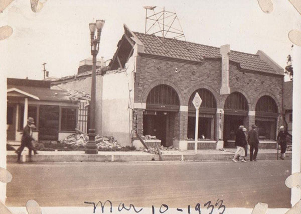 Old photograph of a building with a portion of the outer wall and roof destroyed. Labeled Mar 10 - 1933