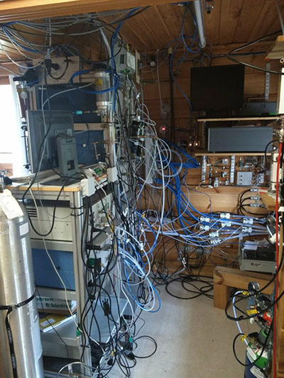 Photograph of a small room filled with equipment and wires.