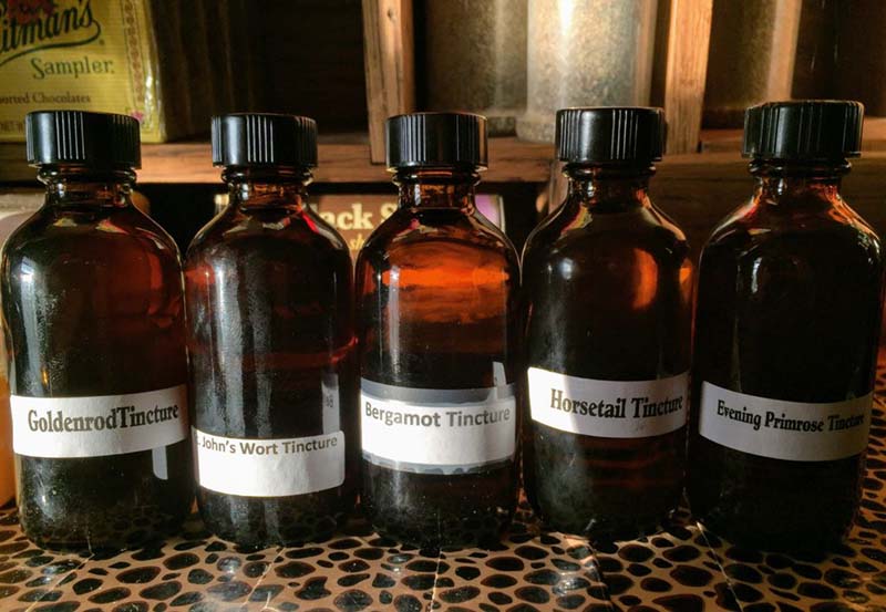 Photograph of small brown glass bottles labelled as: (1) GoldenrodTincture, (2) St. John's Wort Tincture, (3) Bergamot Tincture, (4) Horsetail Tincture, and (5) Evening Primrose Tincture.