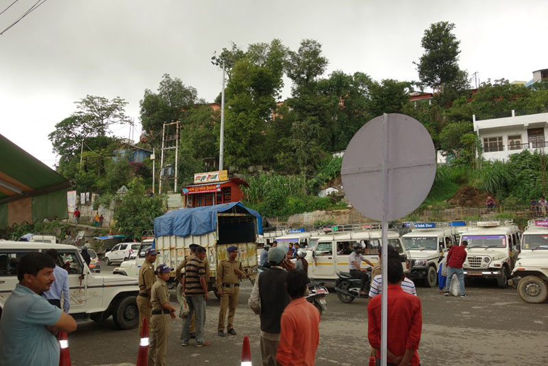 Photograph of police, people and vehicles.