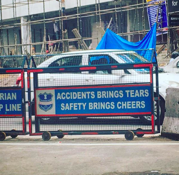 Photograph of road dividers with signs that read "Accidents brings tears. Safety brings cheers."