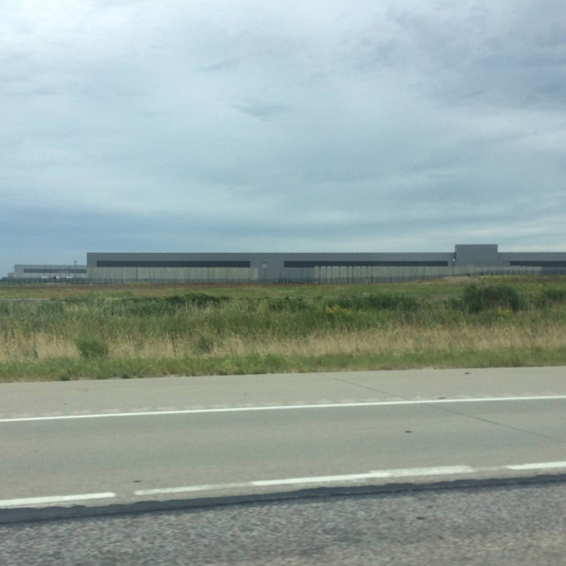 Exterior of a Facebook data center in Altoon, Iowa. Road and field in foreground.