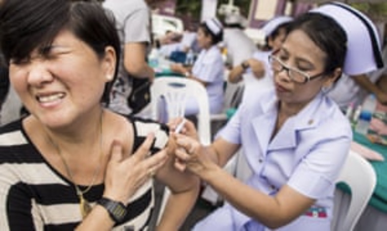 Free immunizations and wellness screenings at the “Return of happiness” street festivities after the military coup in 2014. The picture shows a person receiving a shot from a nurse. Photo credit: The Guardian.