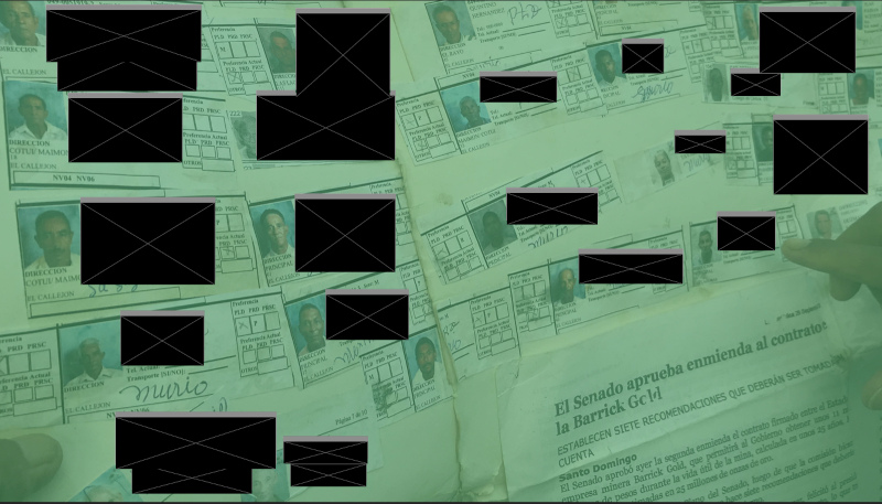A man holds a manila folder with images of persons thought dead due to pollution related illnesses. Identifying information, such as names, are redacted with black blocks.