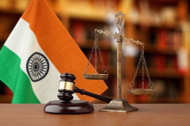 An image of the scales of justice and gavel with the Indian flag in the background.