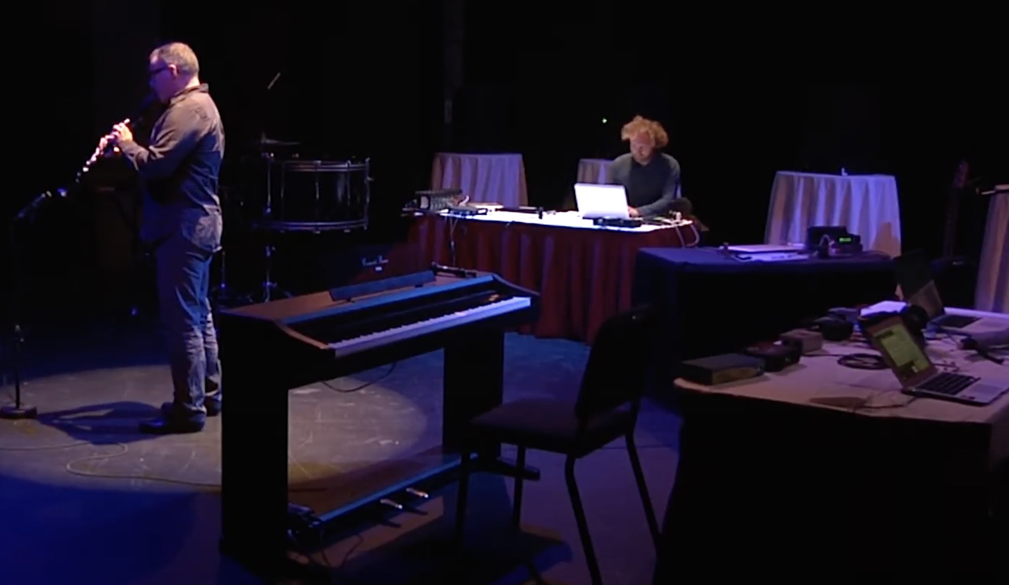 Clarinetist François Houle improvises with Zamyatin, a virtual improviser designed by Oliver Bown. Shown are Houle playing clarinet to a microphone on a stand, an electric piano (unused), and Bown seated at a table in front of a laptop.