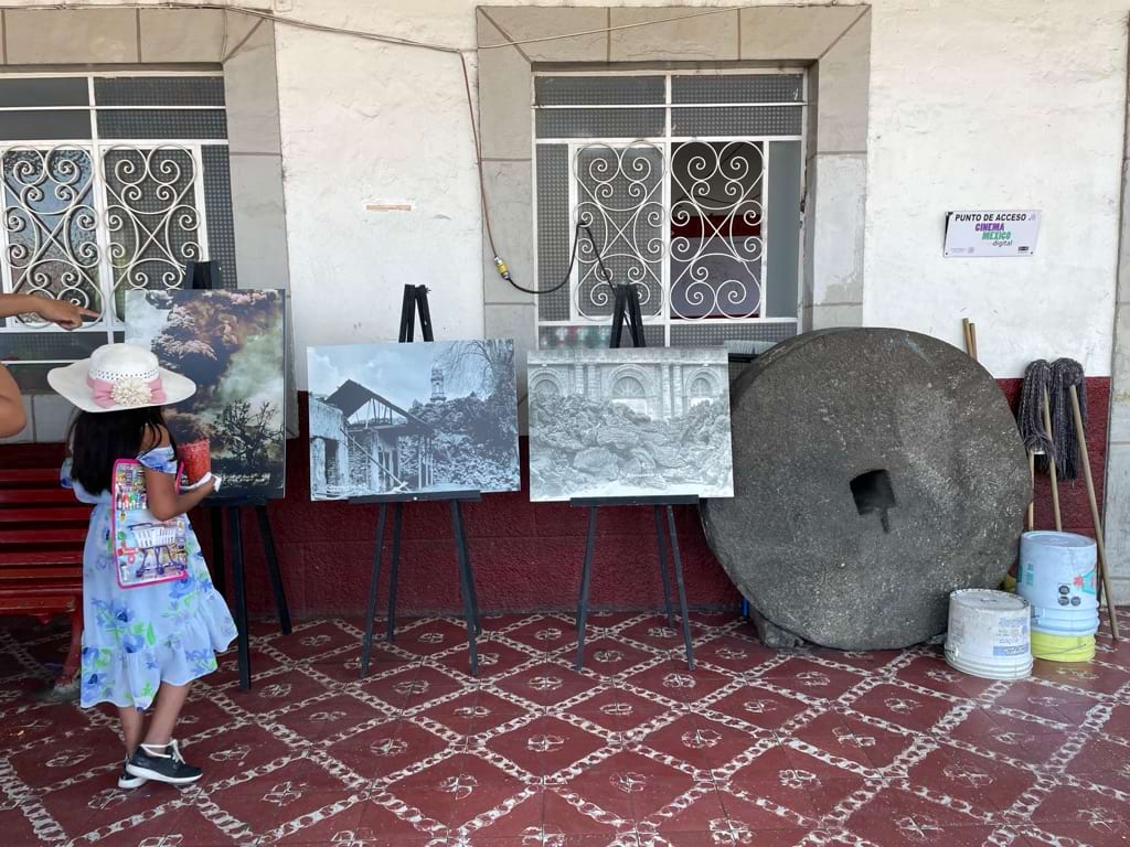 Photo exhibit with a girl standing by one of the images