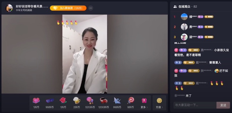 Still from a Douyin video displaying a woman facing the camera. The woman is wearing a white blazer. She is in a white room. Mandarin-language comments are visible to the right of the video.