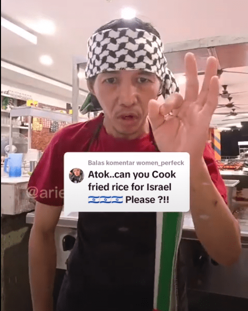 Tiktok User Arief_why1 wears a scarf around his head with the Palestinian flag integrated in. A comment from a TikTok User is overlayed asking Atok whether he can make a fried rice for Israel.