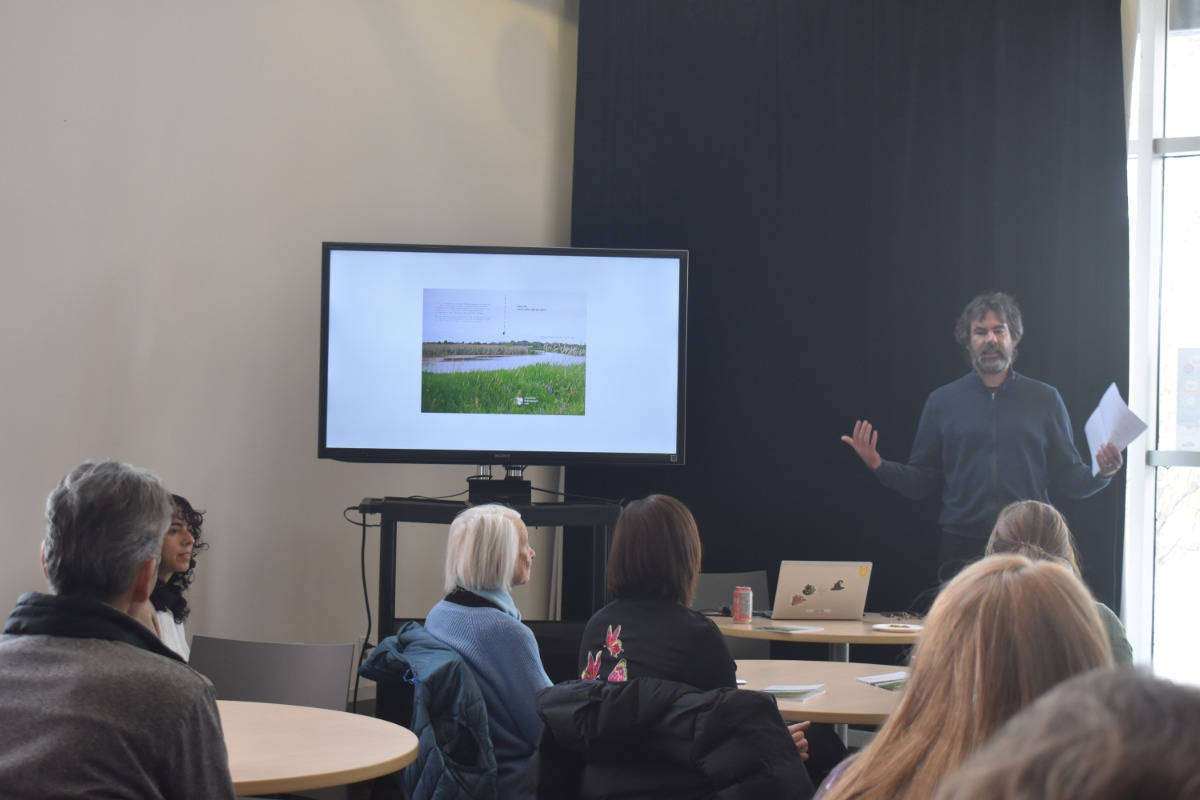 A photo of Kregg Hetherington presenting the research from the collective.