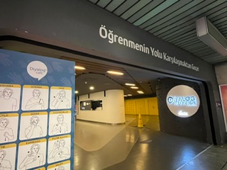 A large open entrance into a separate space within the subway, with white words on a dark overhang.