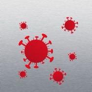 Close-up illustration of a cluster of red germs with circular bodies and surrounded by protruding spikes. The spheres float against a sterile stainless steel background.