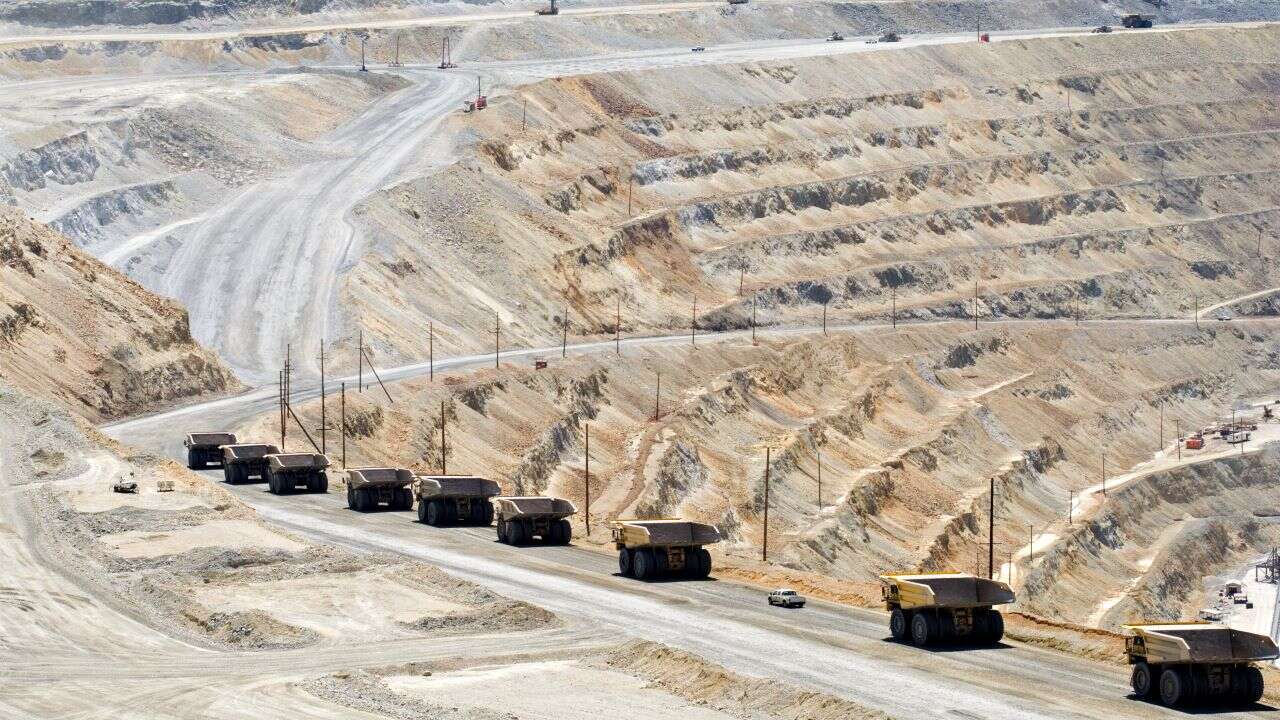 A convoy of trucks travels along a road, transporting materials for the Manono Lithium Tin Project in the Democratic Republic of Congo