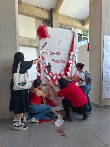 a group of young women putting up a mural about menstruation