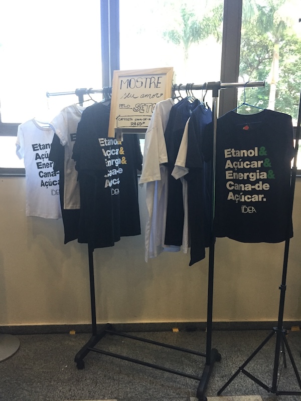 T-shirts hanging on a portable clothing rack in front of a window.