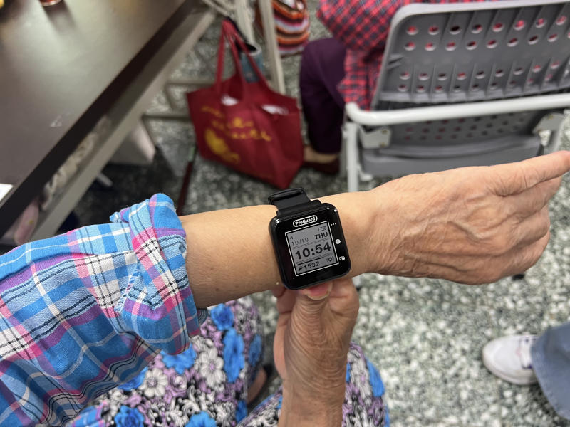 A smart watch worn on an older woman's wrist.