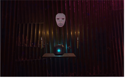 A glowing blue cube flanked by two lit candles sits on a small platform under a white mask floating in front of a corrugated metal wall.
