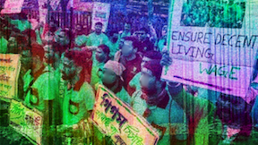 Workers are holding placards in a rally in India. One of them reads saying "ensure decent living wage."