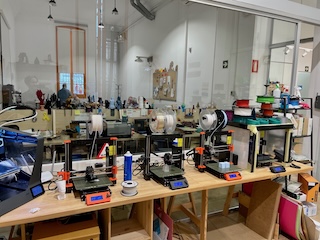 A Fab Lab in Barcelona. Making machines in the foreground with people working in the background.