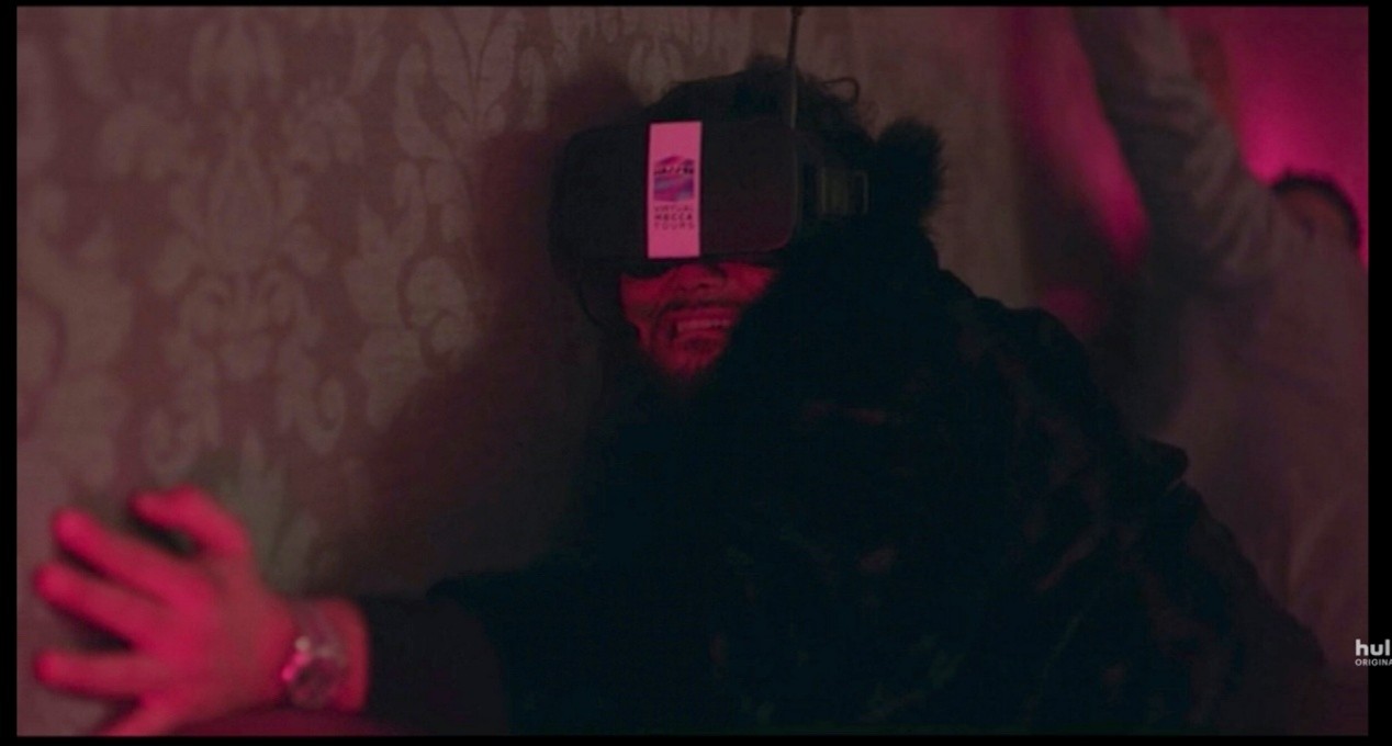 A grainy, red-tinted night-vision shot of a person crouching in a dim, wallpapered room, wearing a boxy camera or viewing device over their eyes. They are crying, with one hand raised in the foreground. A small Hulu Original watermark appears in the lower-right corner.
