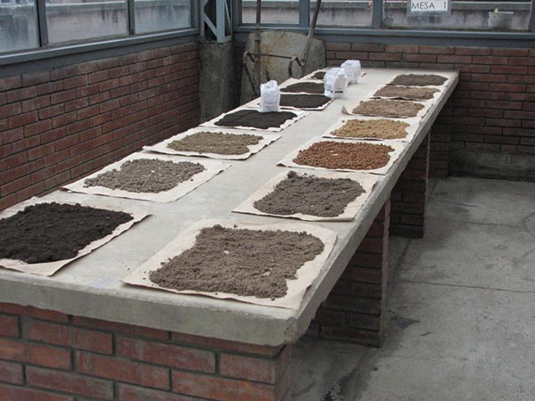 Table with piles of differently colored soil on it.