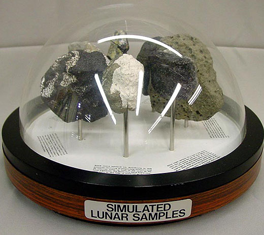 Replica moon rocks under a glass dome on a stand labelled "Simulated Lunar Samples."