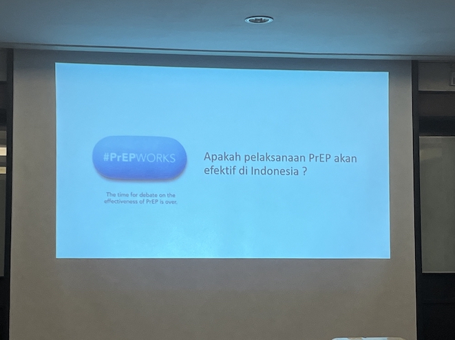 A slide projected onto a white screen with a graphic of a pill inscribed with the hashtag PrEP Works and a subcaption reading: "The time for debate on the effectiveness of PrEP is over.